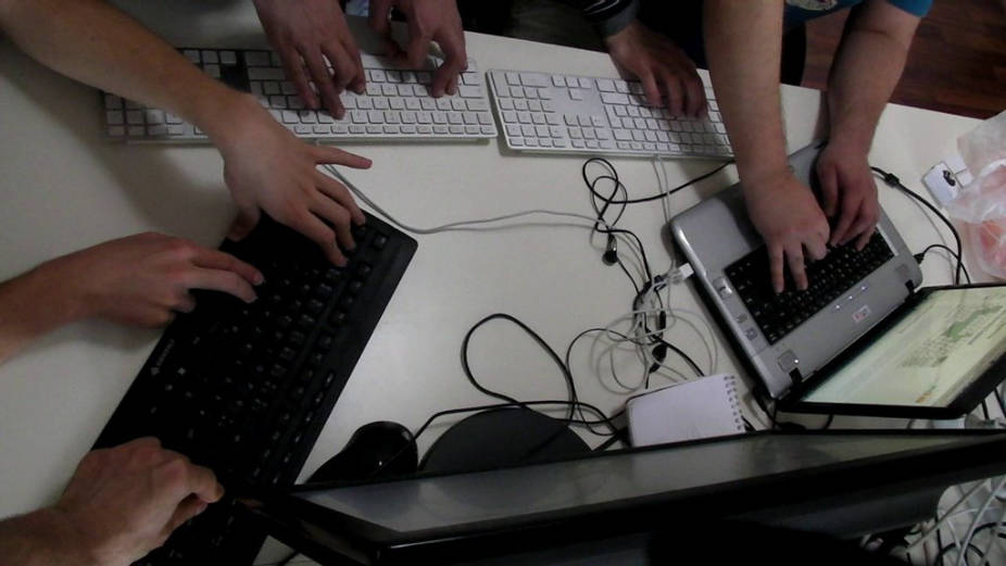 Berlin Min Jam: seven people testing a two button game on a PC